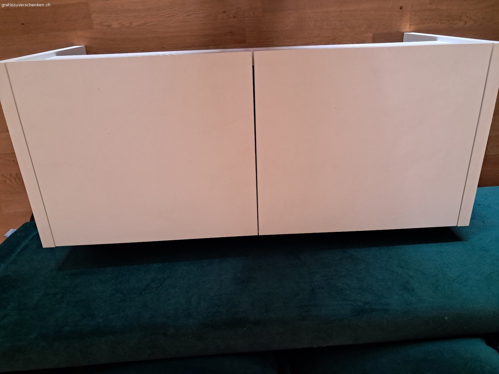 Aufklappbare Garderobensitzbank. Weisse aufklappbare Garderobensitzbank zu verschenken. Länge 1m, Höhe 45.5 cm, Tiefe 41.5 cm. Mit zwei einzeln voneinander zu öffnenden Klappen oben und Gitterhalterungen inwendig. Boden ohne Unterteilung. Muss abgeholt werden.