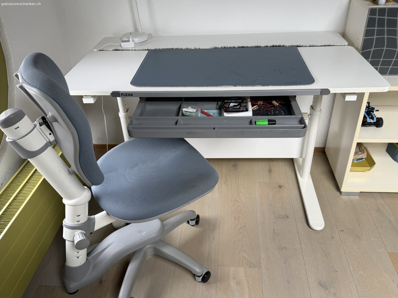 FLEXA Kinderschreibtisch mit Bürostuhl - gratis abzugeben. Wir verschenken einen höhenverstellbaren Kinderschreibtisch der Marke FLEXA inklusive passendem, ergonomisch verstellbarem Kinderbürostuhl.

Ausstattung:

* Höhenverstellbarer Schreibtisch
* Masse der Tischplatte: 120 × 70 cm
* Aktuelle Tischhöhe: 75 cm (verstellbar)
* Neigungsverstellbare Tischplatte
* Praktische Schublade mit mehreren Fächern
* Höhenverstellbarer Kinderbürostuhl mit Rollen
* Robuste und stabile Ausführung

Beide Möbelstücke sind gebraucht, aber in gutem, funktionsfähigem Zustand. Normale Gebrauchsspuren sind vorhanden (siehe Fotos).