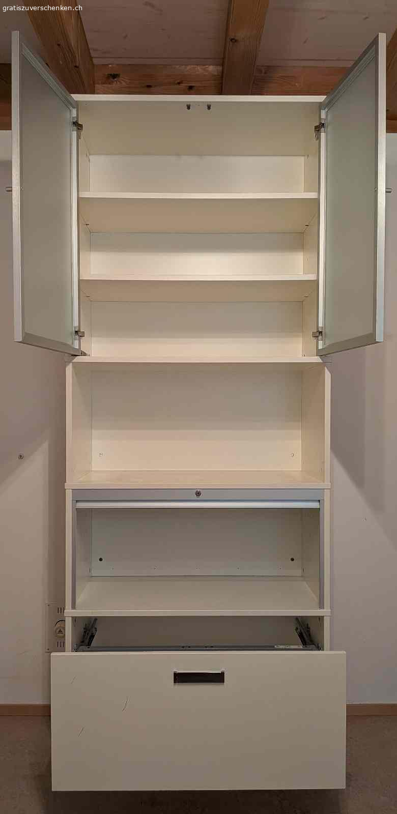 Hübsche schlichte Vitrine für Bücher und Anderes. Hübsches mehrteiliges Gestell mit Schublade und Hängeregistern, Bereich mit Rollade verschliessbar, offener Bereich und Ablage, Bereich mit 2 Glastüren.

Masse: Höhe: 215cm - Breite: 85 cm - Tiefe: 43 cm