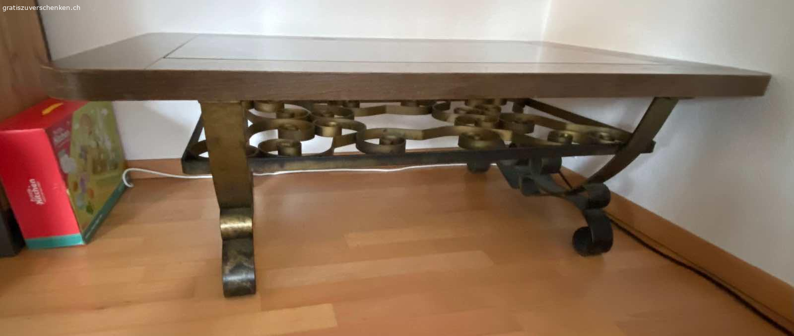 Massiver Salontisch. Ziemlich schwer.
Verschnörkelter Unterbau aus Metall. Messingfarben.
Massive Holzumrandung, die ein neuer Anstrich vertragen kann, da Gebrauchsspuren vorhanden sind.
Eingelegte Glasplatte. Herausnehmbar.
Der stabile Tisch hält es auch bestens aus, wenn man sich darauf setzt. 
Länge 130 cm
Breite 80 cm
Höhe 45 cm

Abzuholen in 5408 Ennetbaden 
Bitte keinen Telefonanruf, nur Mail oder WhatsApp.