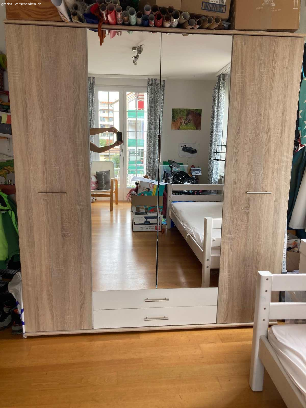 Schrank mit Spiegel. Schrank zu verschenken
4 Türen, 2 Schubladen
Maße: Breite 177 cm; Höhe 197 cm; Tiefe  56 cm
Der Schrank wurde schon mindestens zwei mal aufgebaut. Die Schubladen sind schon mal aus der Schiene gebrochen, wurden repariert und laufen jetzt wieder gut. Über der Schublade rechts ist das untere Brett etwas kaputt.