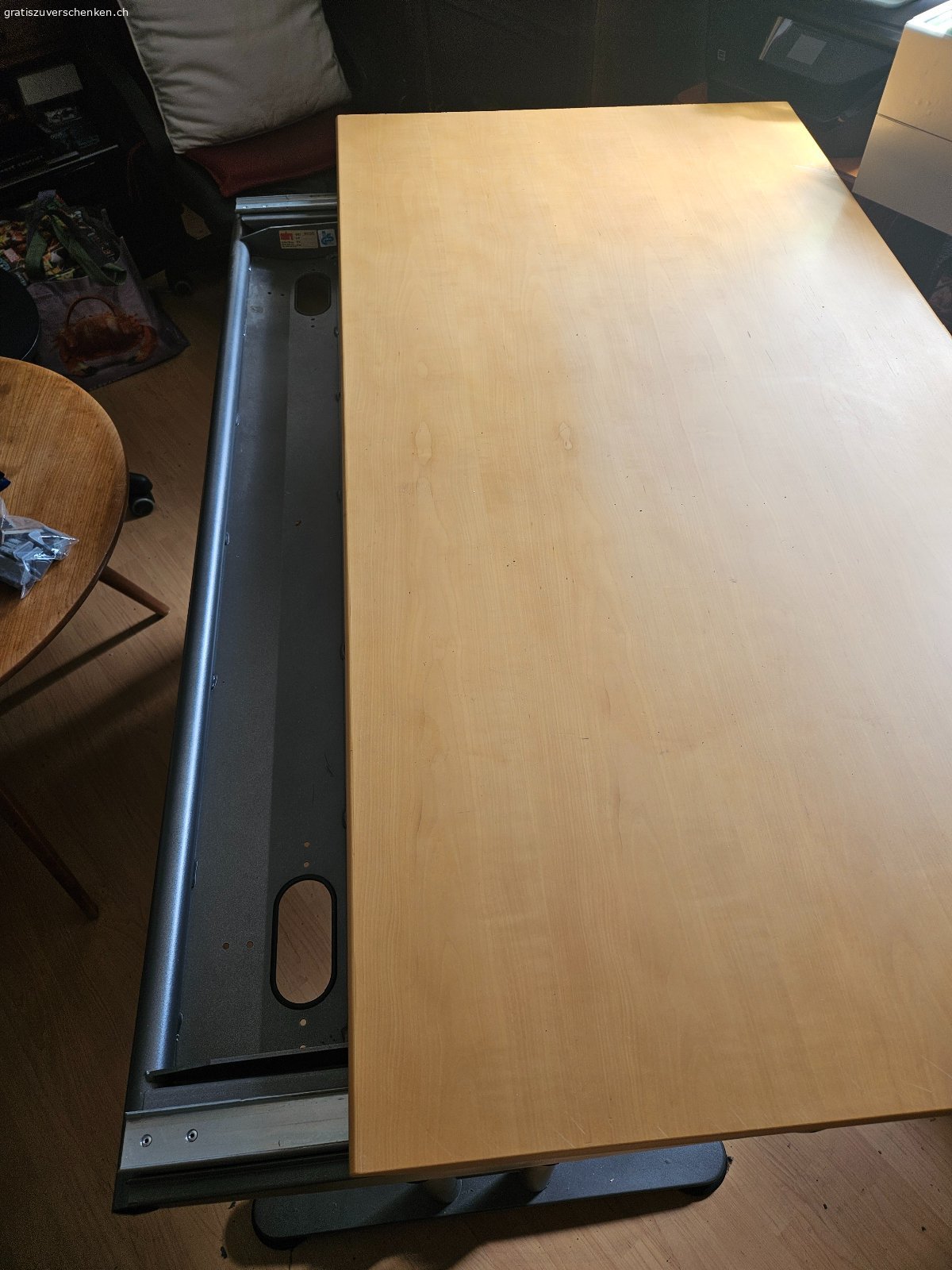 Schreibtisch höhenverstellbar mit separatem Korpus. Der Schreibtisch hat die Abmessung 170 x 85 cm. Er ist mit einer Kurbel in der Höhe verstellbar und die Tischplatte kann für den Zugang zum Kabelkanal verschoben werden