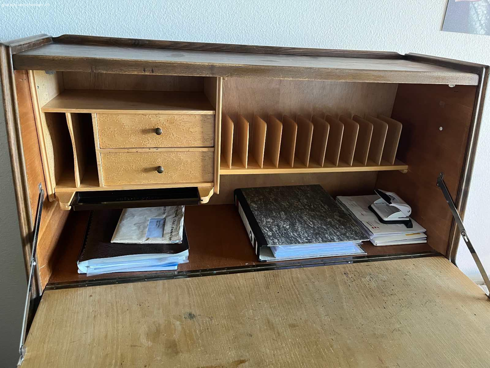 Sekretär. Schöner Sekretär. Etwa 60 Jährig. Innen hat es noch zwei kleine Schubladen. Unten hat es drei Schubladen und ein Türchen. Masse: Höhe 125 cm. Breite 100. Tiefe 44 cm. In Uster abzuholen.